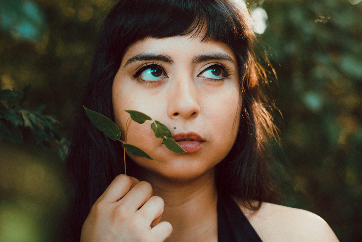 Holding leaves up to lips close up portrait 