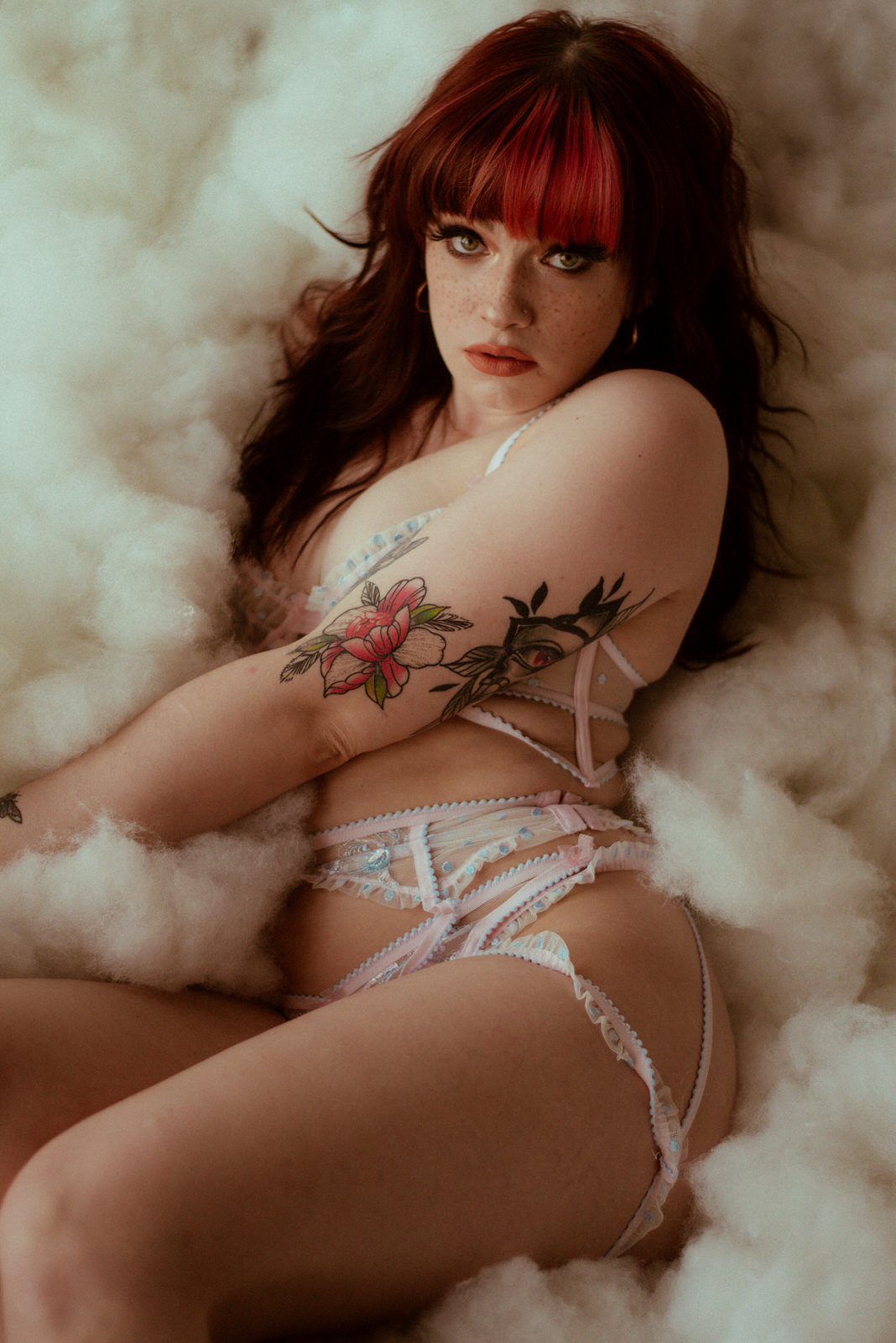 Beautiful woman with tattoos posing in lingerie in Dallas boudoir studio.