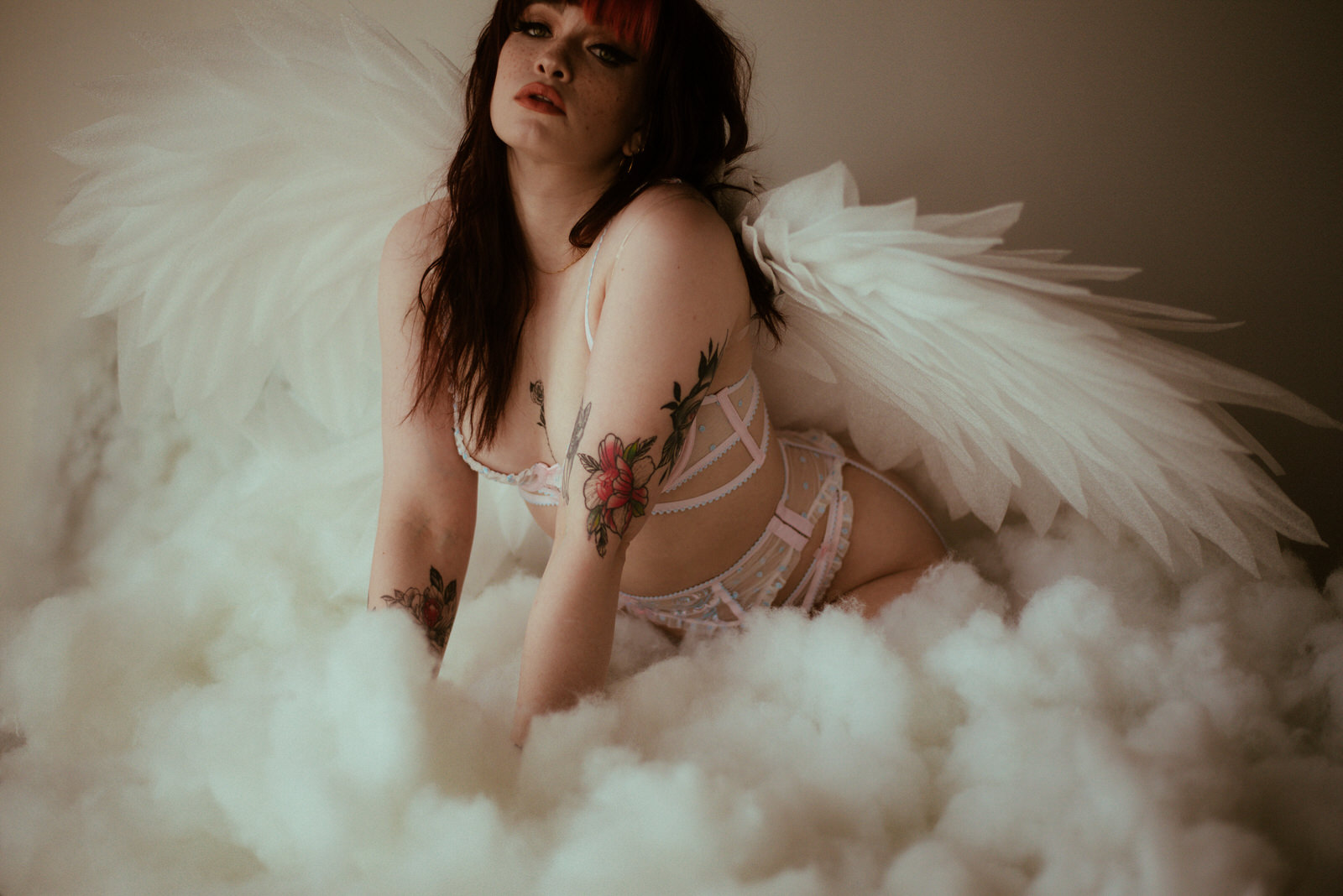 A woman in lingerie posing with angel wings. Angel wing boudoir Dallas TX