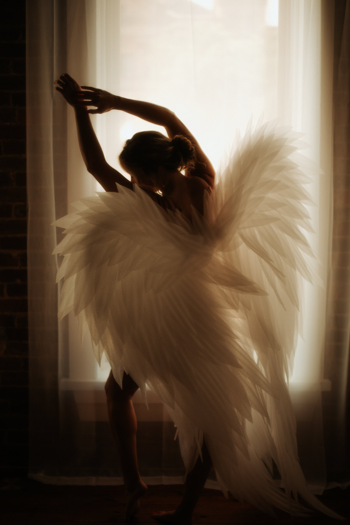 A woman with angel wing posing in a Dallas photography studio.