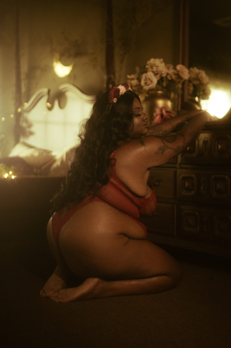 A woman in a red lingerie crouching on the floor.