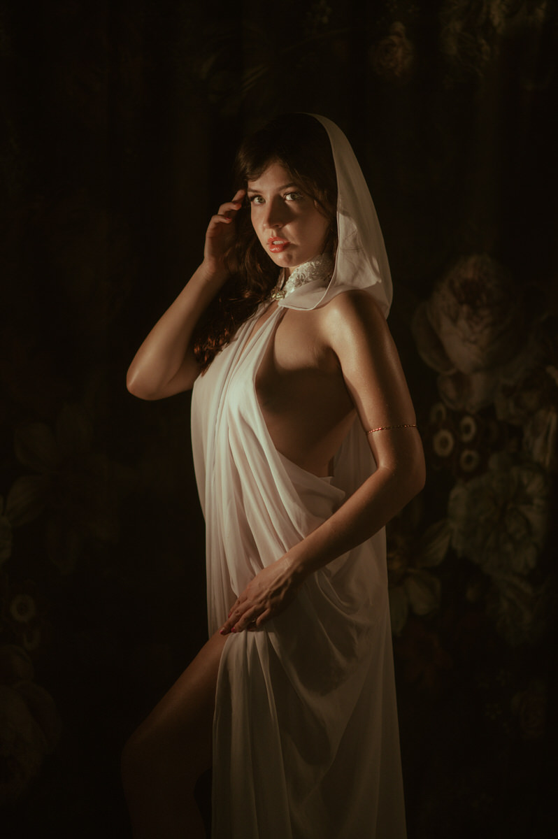 A woman in a white dress posing for Dallas Boudoir Photography.