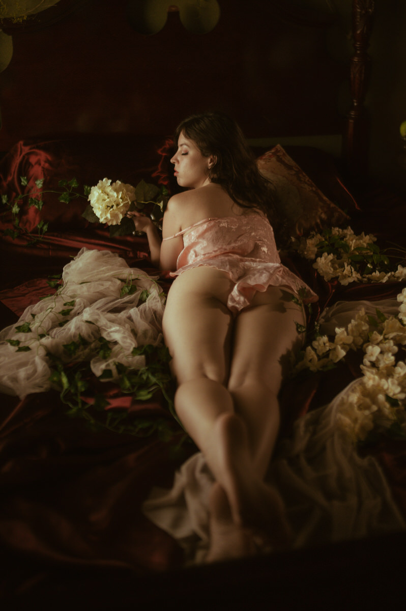 Dallas Boudoir Photography of a woman laying on a bed with flowers.