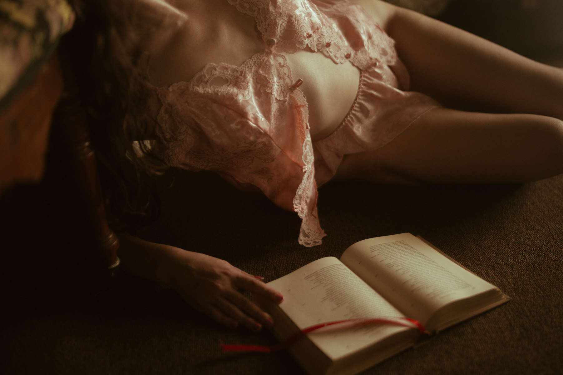 A Dallas woman enjoying boudoir photography while reading a book.