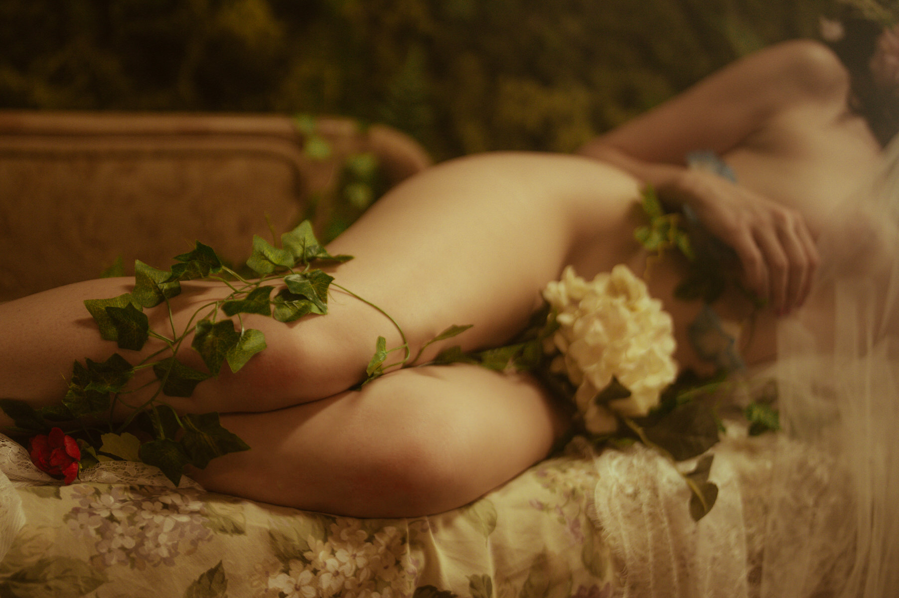 Dallas Boudoir Photography featuring a naked woman on a bed adorned with ivy.