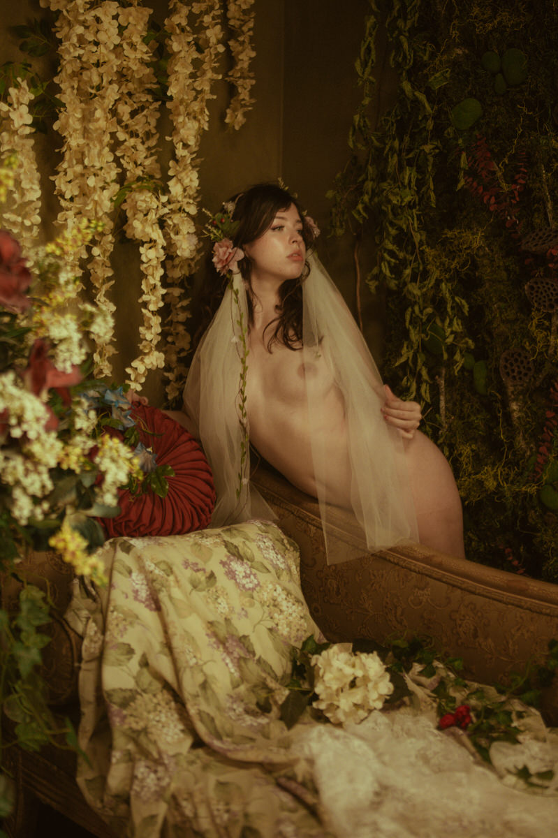 Dallas Boudoir Photography featuring a woman posing in a room full of flowers.