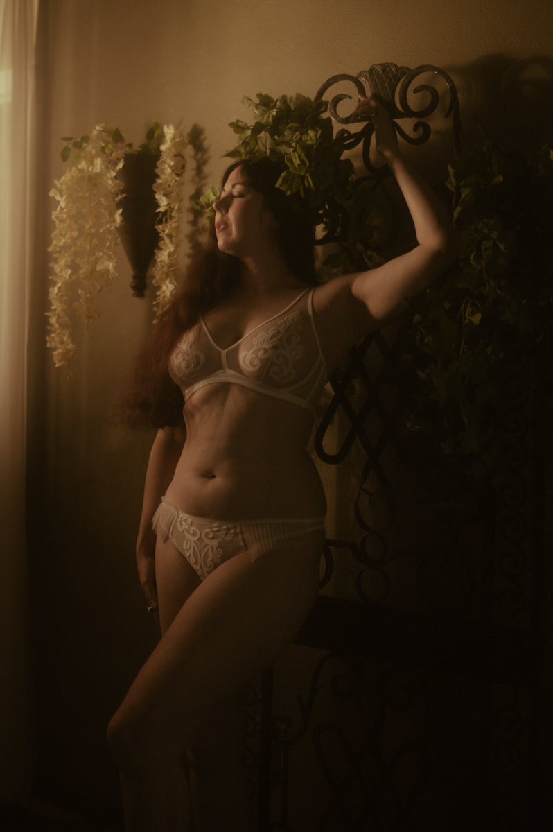A woman posing for a boudoir photoshoot wearing Empress Mimi lingerie.