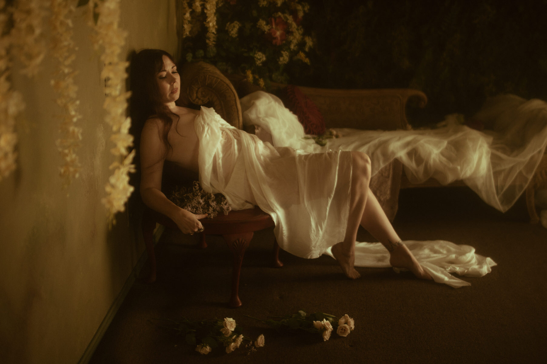 A woman covered by white fabric, posing artistically on a chair, capturing the essence of Texas boudoir.
