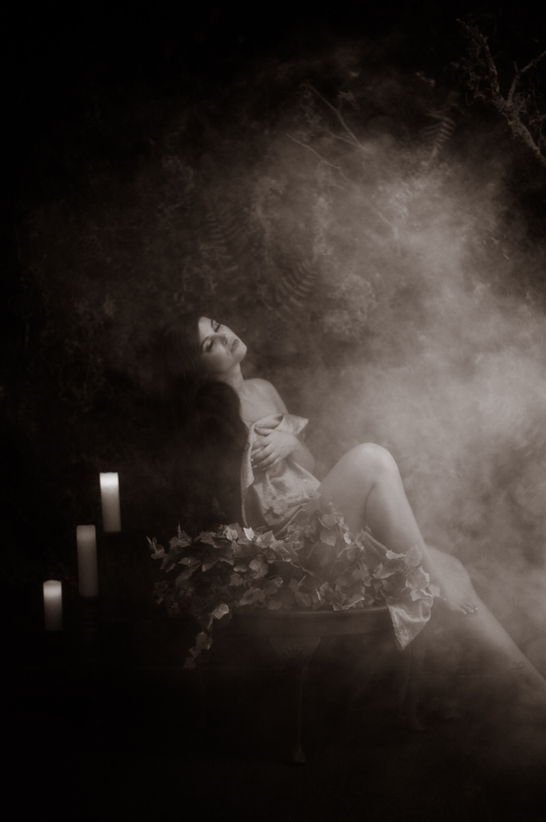A woman posing for a boudoir session with fog.