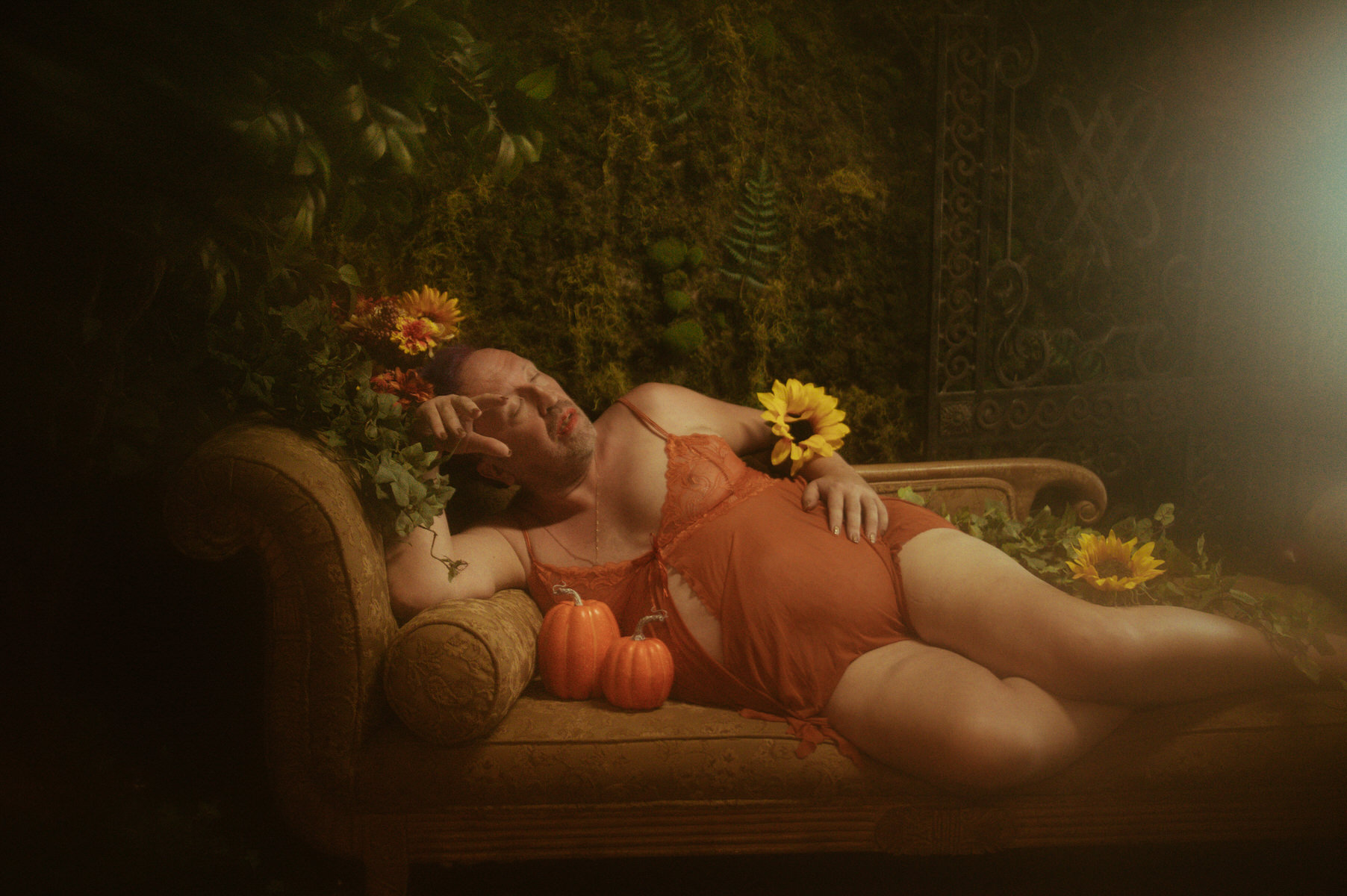A woman reclining on a couch with sunflowers at a Dallas boudoir studio.
