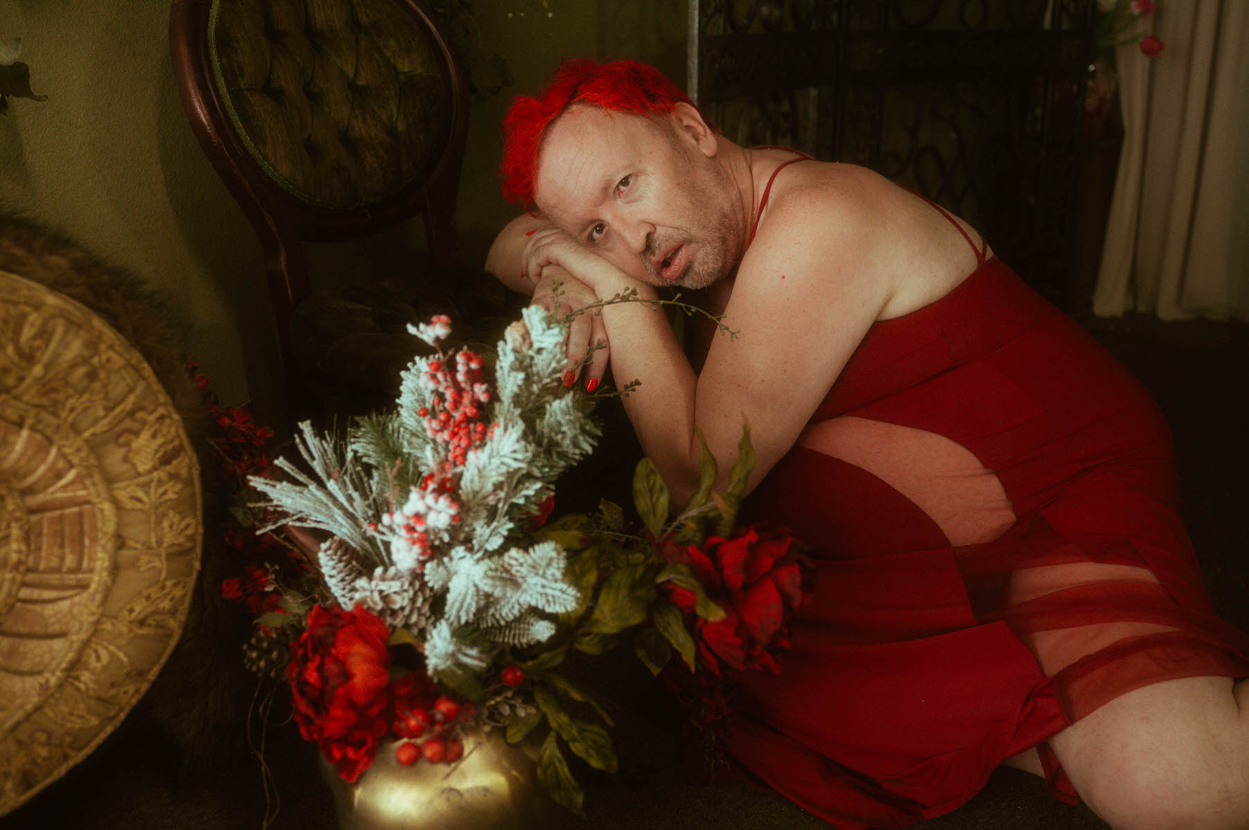 A trans woman in a red dress laying on the floor at a Dallas boudoir studio.