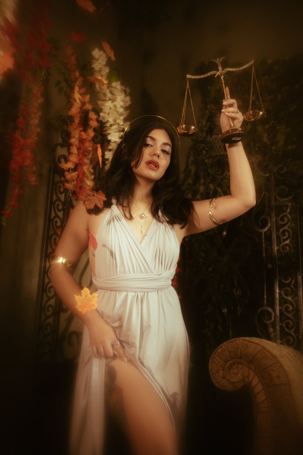 a woman in a white dress holding scales of justice for a libra photoshoot in Dallas, TX.