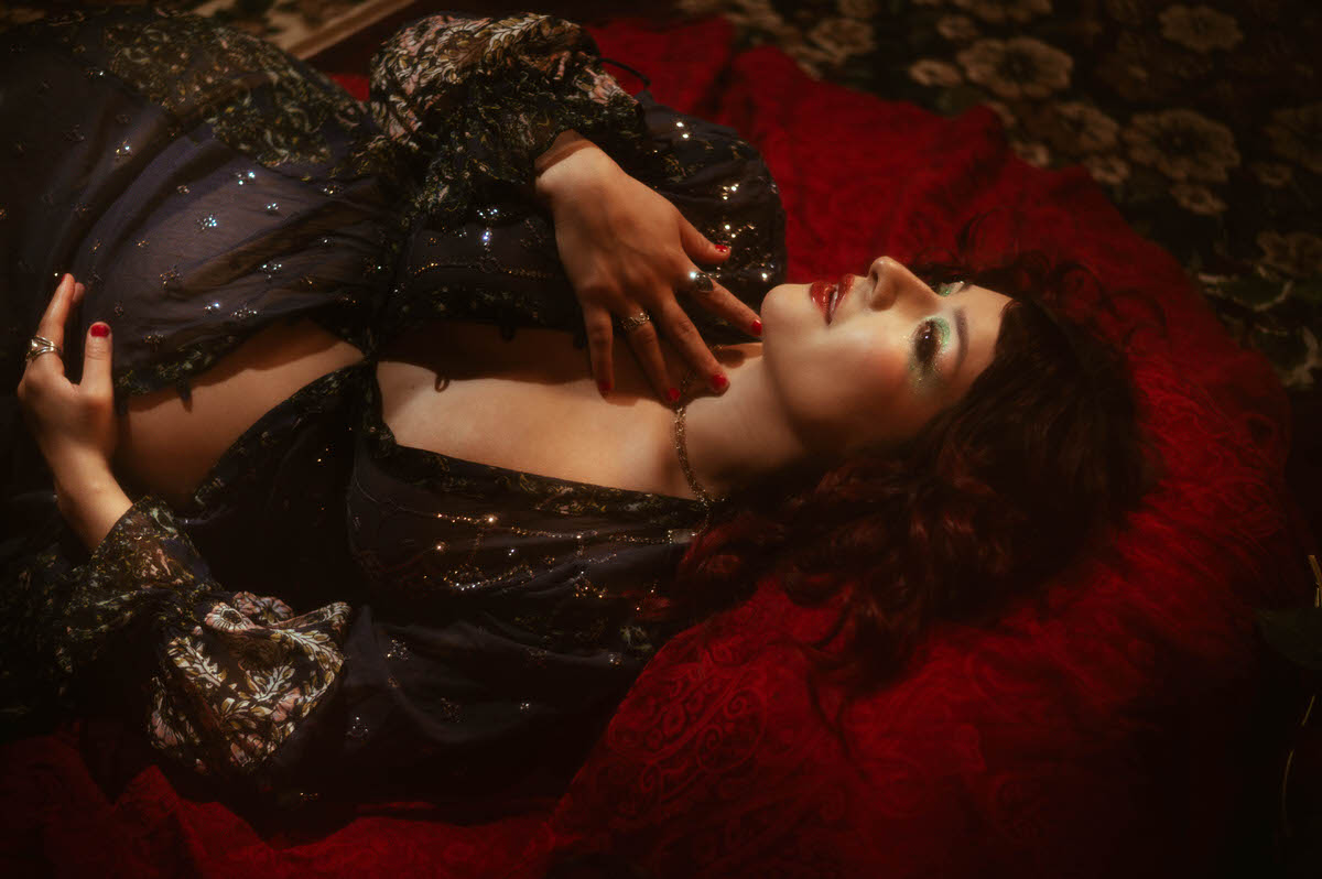 Artistic maternity boudoir portrait featuring a moody, ethereal scene with soft, dramatic lighting, highlighting the subject's form and expression.