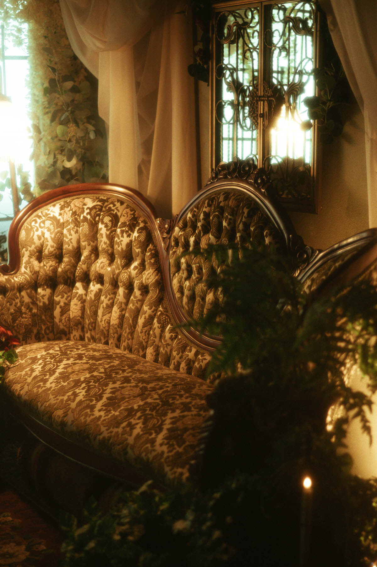 Vintage Victorian-style sofa with carved wood trim and damask upholstery, softly lit by natural window light and surrounded by romantic drapery, greenery, and floral accents in Royal Lune Studio’s spring boudoir setup in this Dallas boudoir studio.