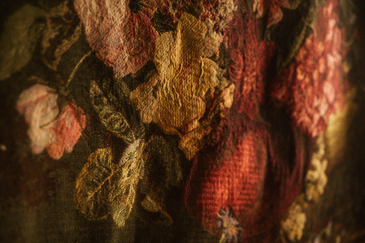 Detail of vintage floral tapestry at Royal Lune Studio showcasing textured yellow, pink, and red flowers with leafy accents, part of the romantic decor in this Dallas boudoir studio.