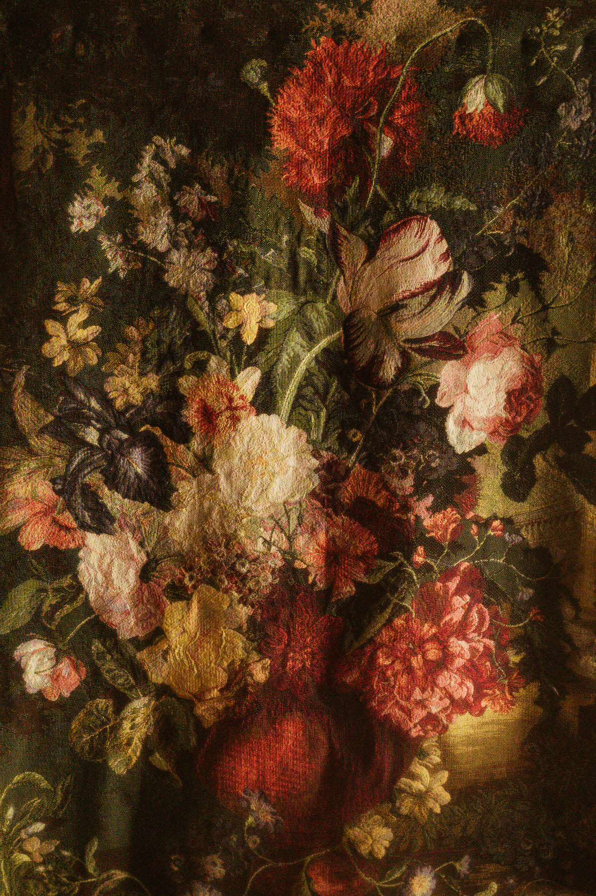 Close-up of a vintage floral tapestry at Royal Lune Studio featuring richly woven flowers in warm reds, creams, yellows, and purples, used to enhance the romantic, antique atmosphere of the Dallas boudoir studio setup.