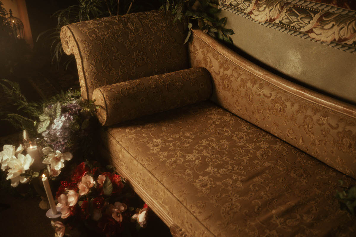 Tapestry-upholstered vintage lounge from Royal Lune Studio styled with silk florals, taper candles, and romantic greenery, part of the spring boudoir setup in this Dallas boudoir studio rental.