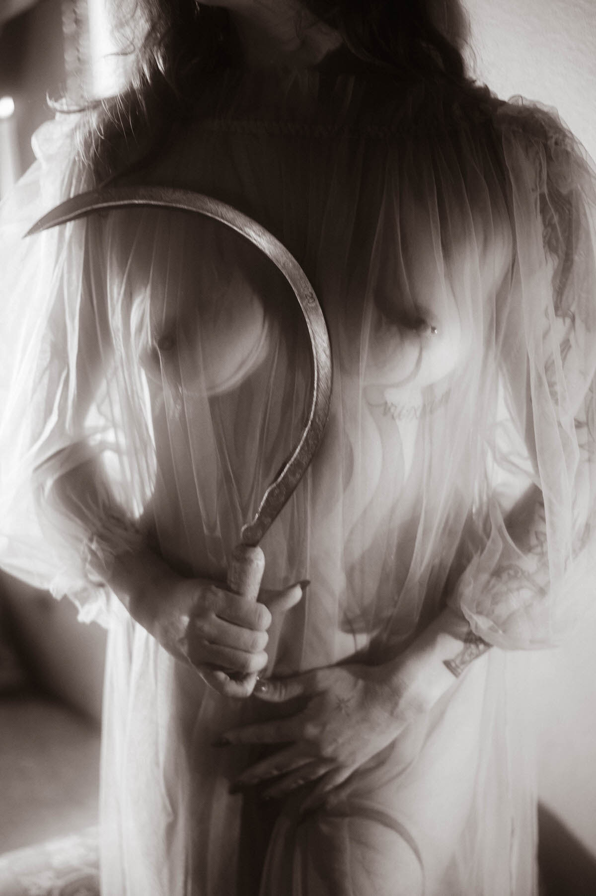 This moody fall photos black and white close up frames a sickle held against sheer tulle, paying homage to the composition of Allegory of Summer. Royal Lune Photo.