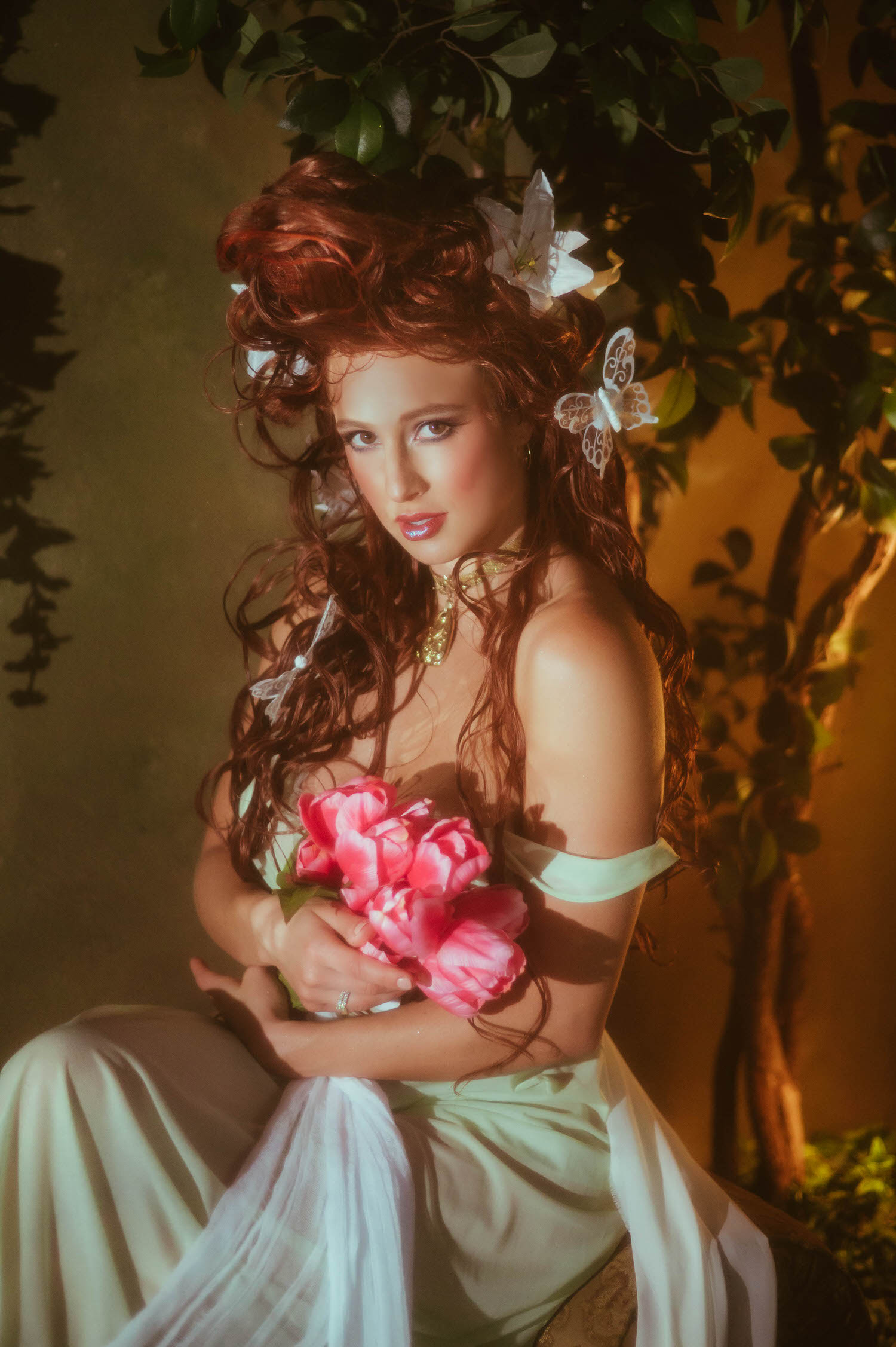 A close portrait showcasing Art Nouveau style from Royal Lune Studio. Located in the Dallas area, the scene features a model holding pink flowers under a tree canopy.