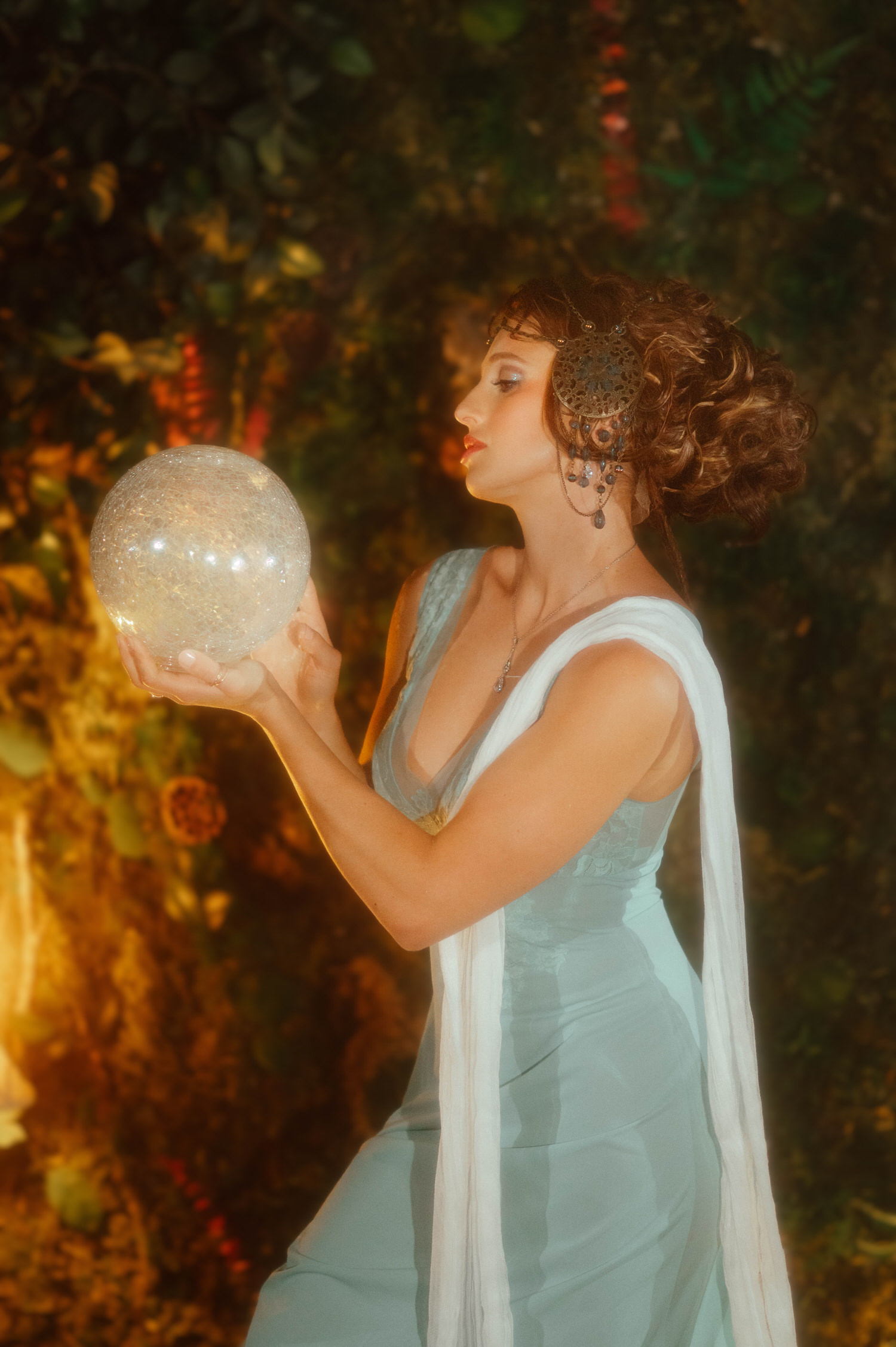 Art Nouveau style portrait from Royal Lune Studio. Located in the Dallas area, the scene features a woman holding up a glowing crystal globe prop.