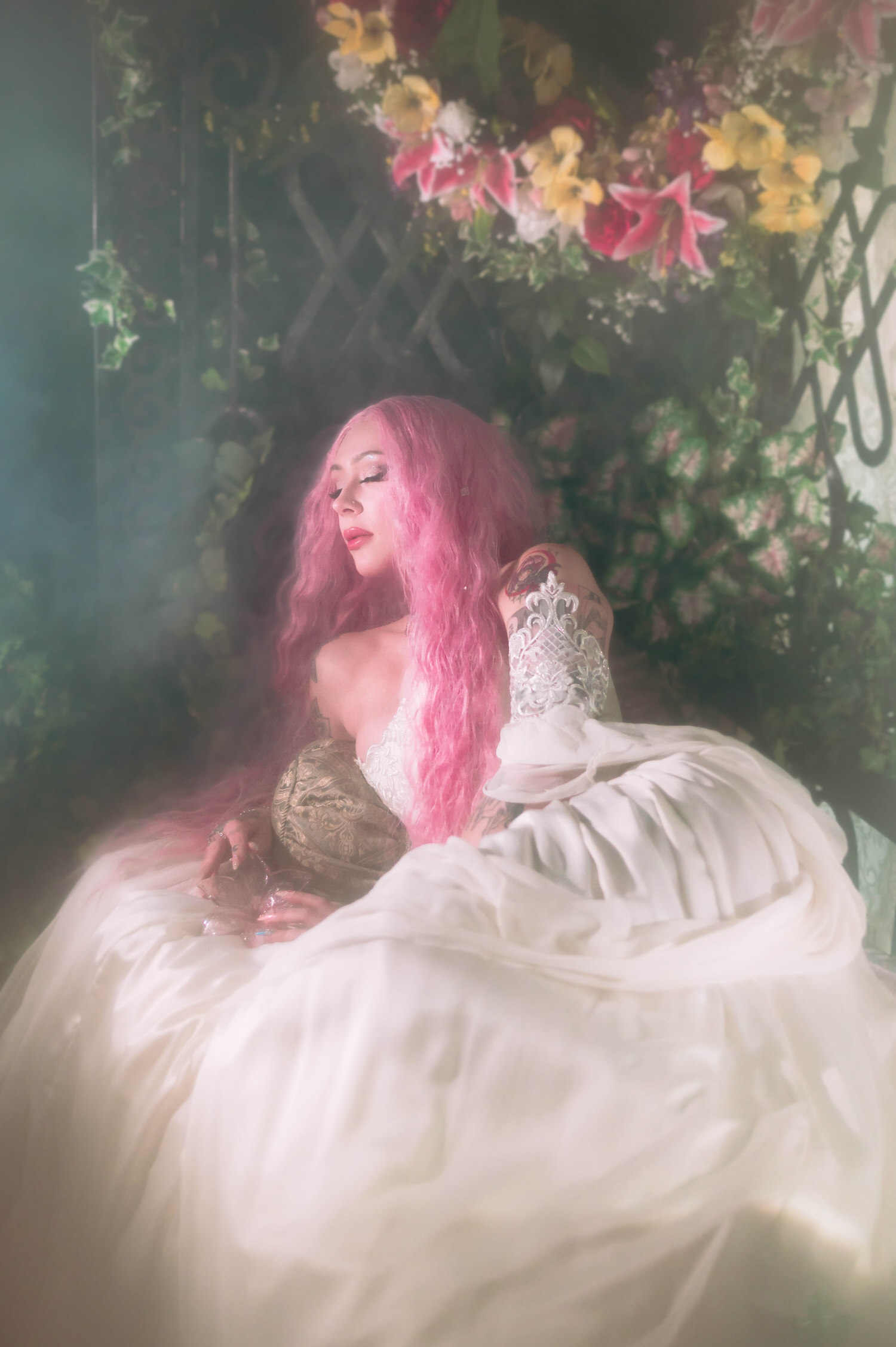 Bride in a renaissance-inspired fantasy bridal gown posed against a floral arch and ivy-covered ironwork, styled for renaissance fair wedding photography.