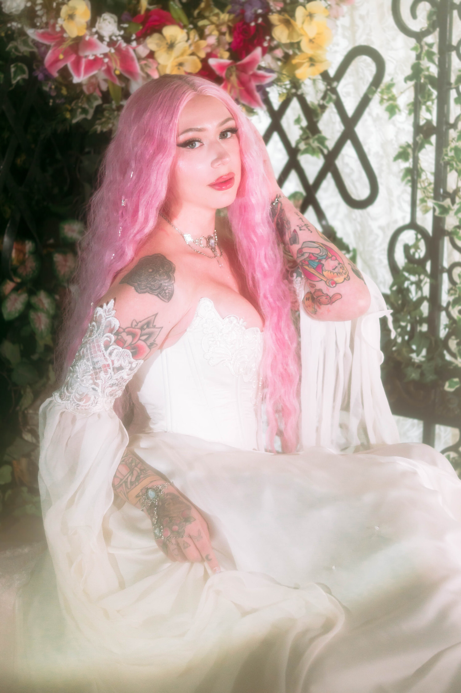 Fantasy bridal photos of bride seated in an ivory fairytale bridal gown, framed by colorful blooms and vintage ironwork at Royal Lune Studio.