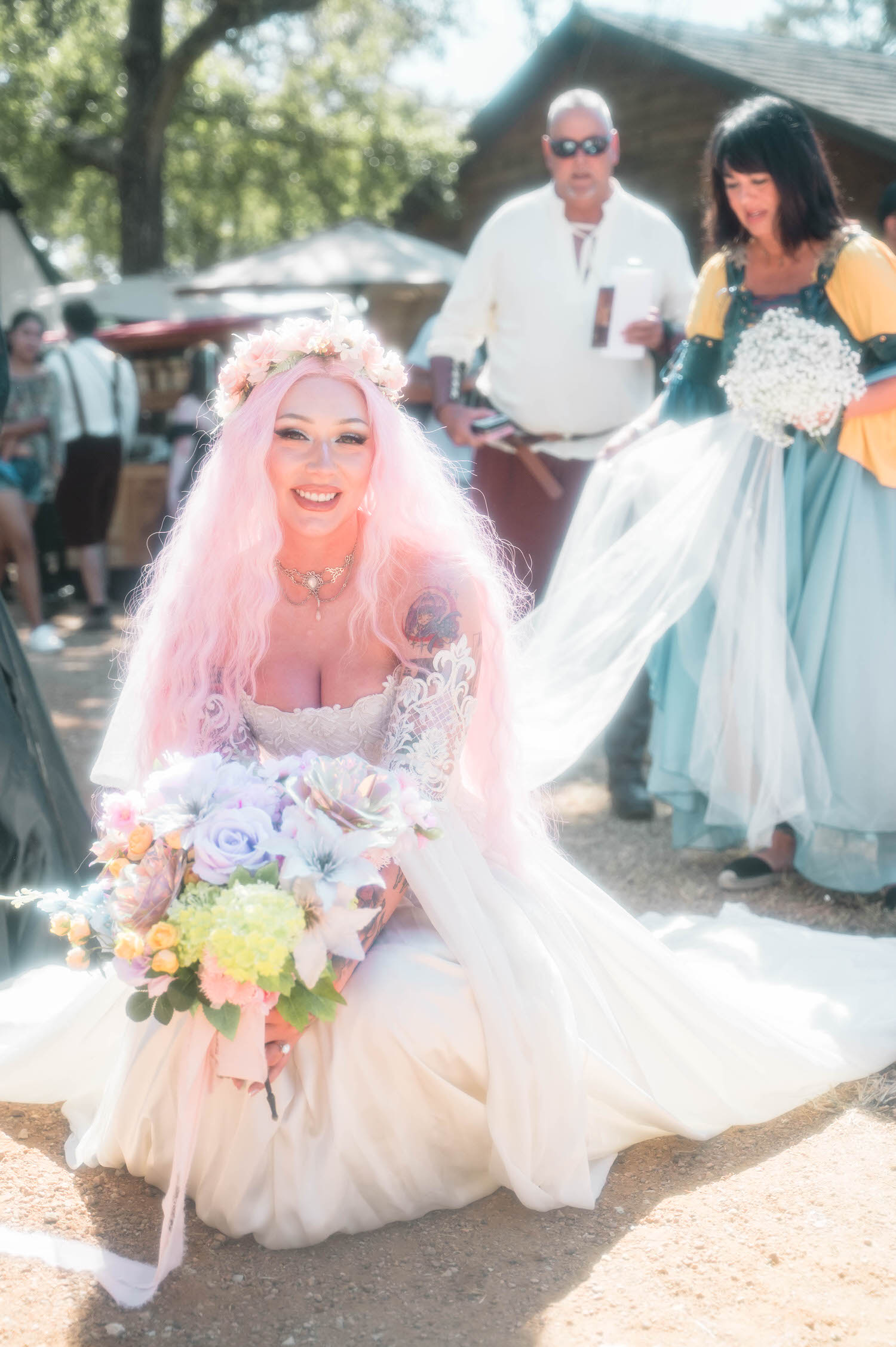 The bride poses with a vibrant pastel bouquet of roses and lilies, her pink hair and flower crown glowing in the sunlight before the ceremony begins. Romantic florals like these are a hallmark of a fantasy wedding photographer's portfolio. Royal Lune Photo.