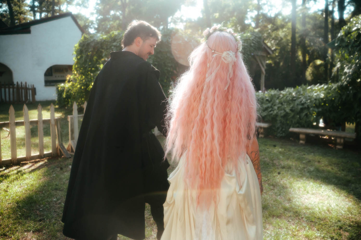 The bride and groom walk hand in hand away from the reception at the Italian Village, her pink hair cascading down the back of her flowing gown. Royal Lune Photo.