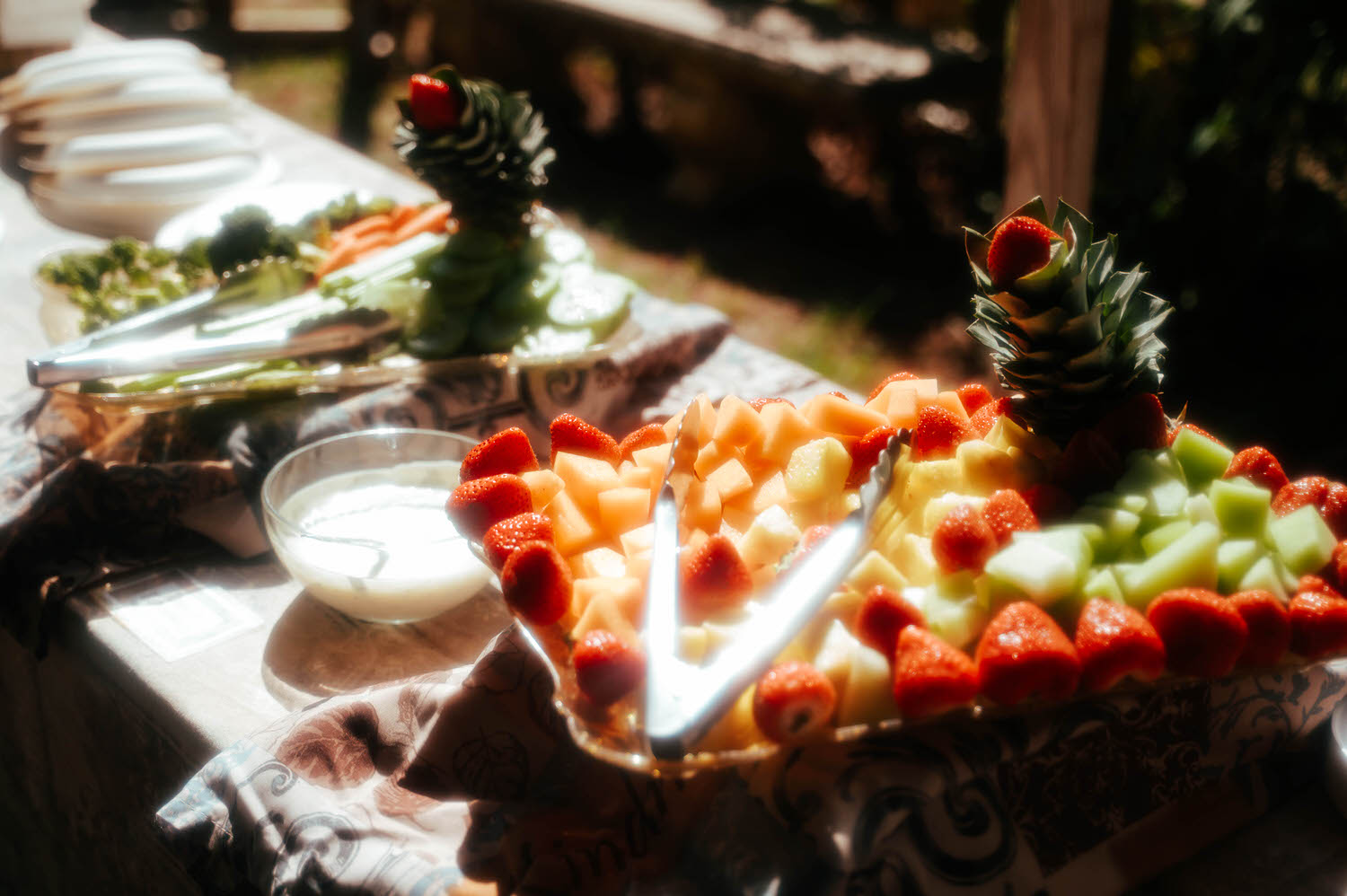 A fruit platter with strawberries, melon, and pineapple is arranged beside a creamy dipping sauce on the reception table at the Italian Village. Fresh, vibrant details like this elevate any Texas Renaissance Festival wedding reception. Royal Lune Photo.