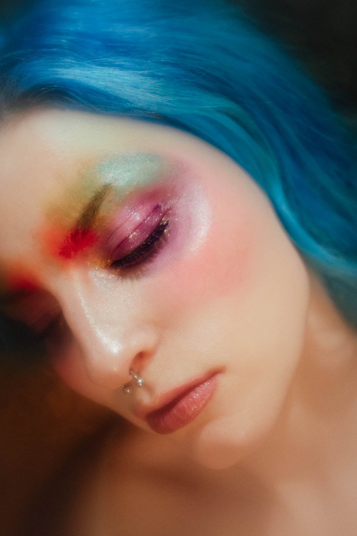 Extreme close up portrait of a woman's face with closed eyes and watercolor style eyeshadow in yellow, pink, and purple, photographed by a Dallas fine art photographer at Royal Lune Photo.