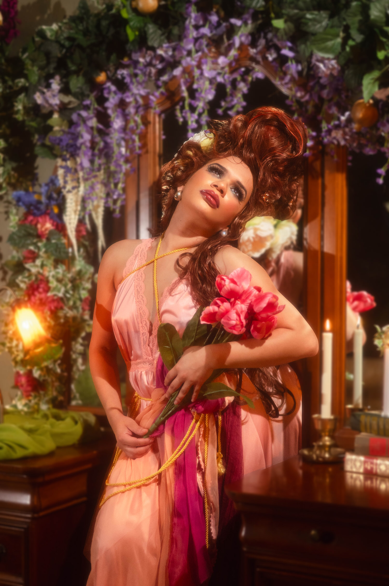 Woman leaning back with closed eyes while holding a bouquet of pink tulips near a mirrored vanity, Royal Lune Photo.