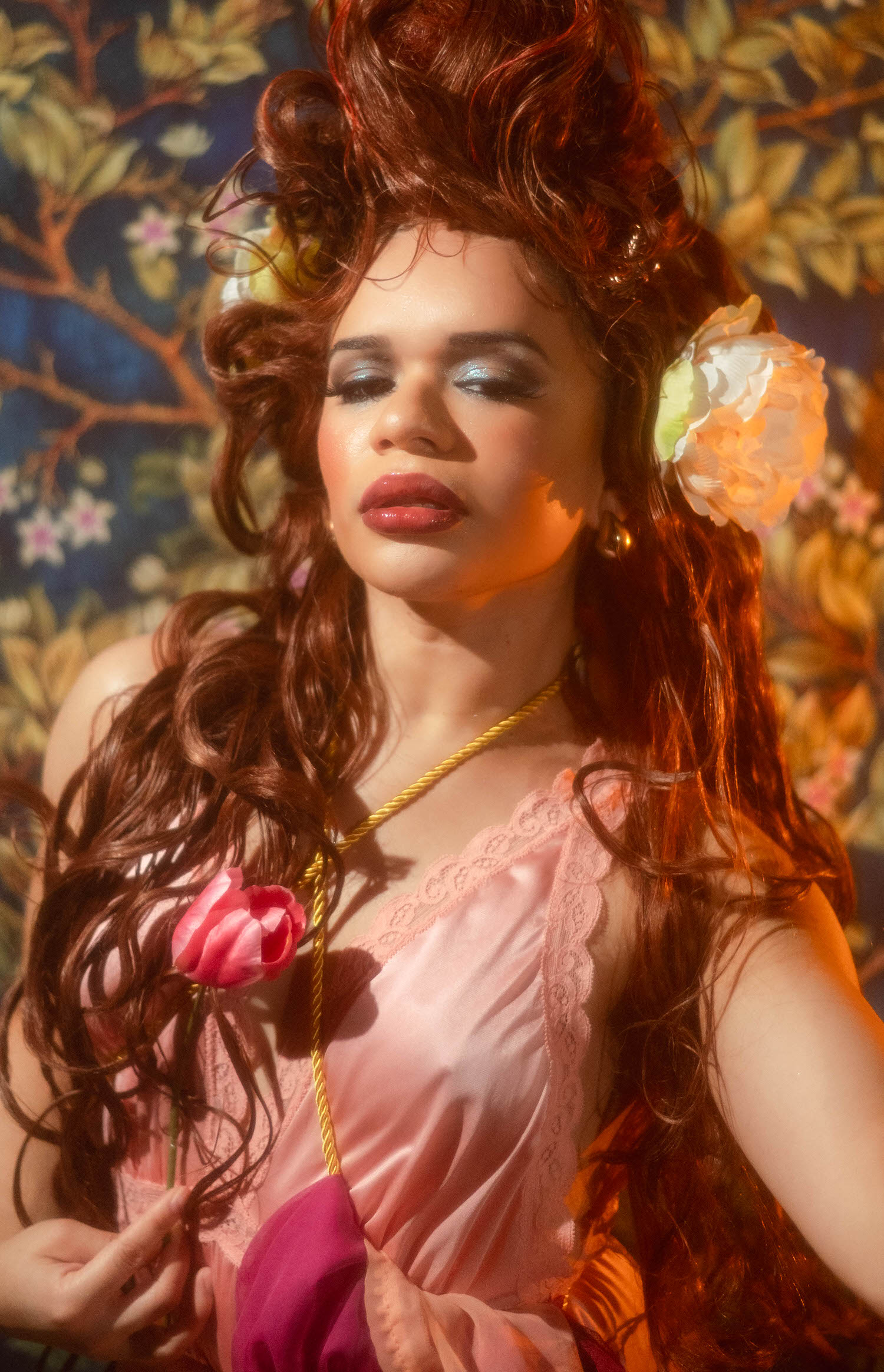 Close up portrait of a woman with a peony tucked into her curling wig and a pink tulip resting near her chest, Royal Lune Photo.
