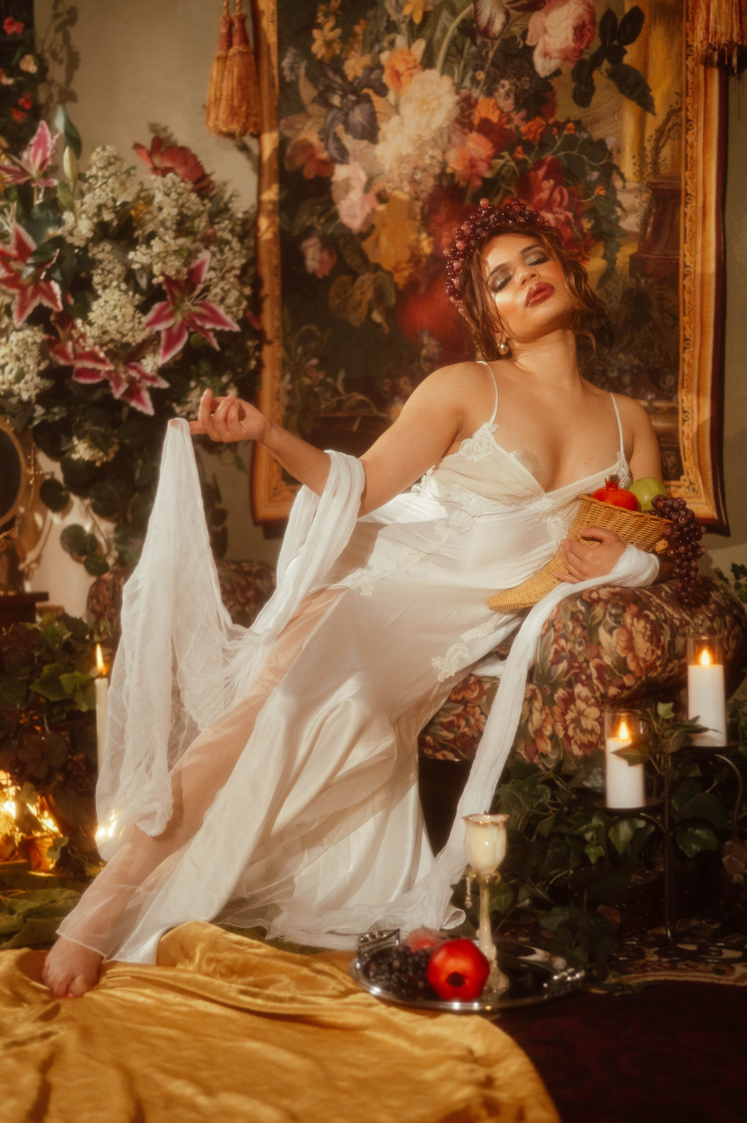 Woman leaning back with sheer white fabric draped from her arm in this art nouveau styled shoot, a fruit basket resting at her side, Royal Lune Photo.