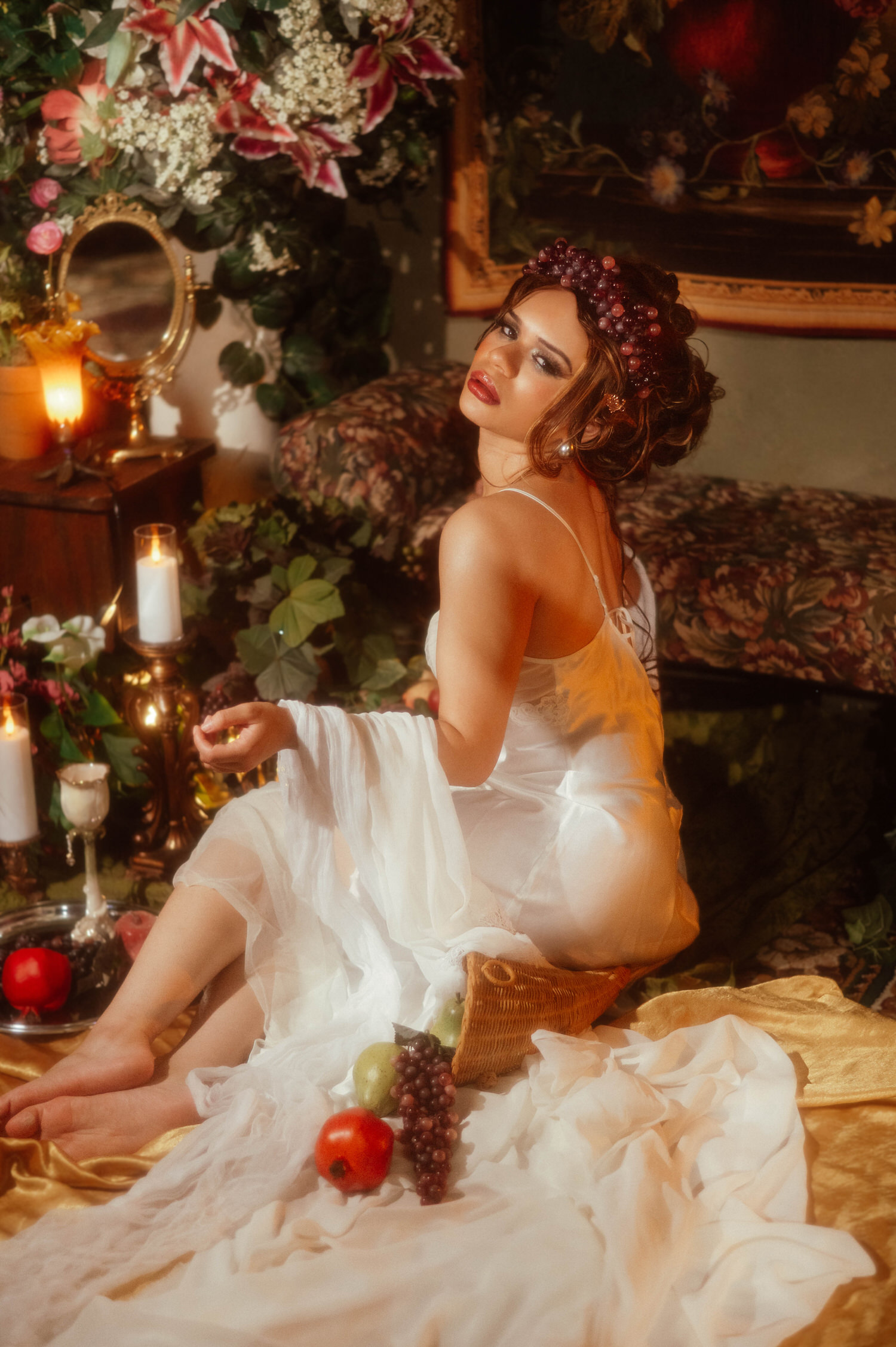 Woman glancing over her shoulder during this Dallas Fort Worth fine art photographer session, seated among grapes, pomegranate, and pears, Royal Lune Photo.