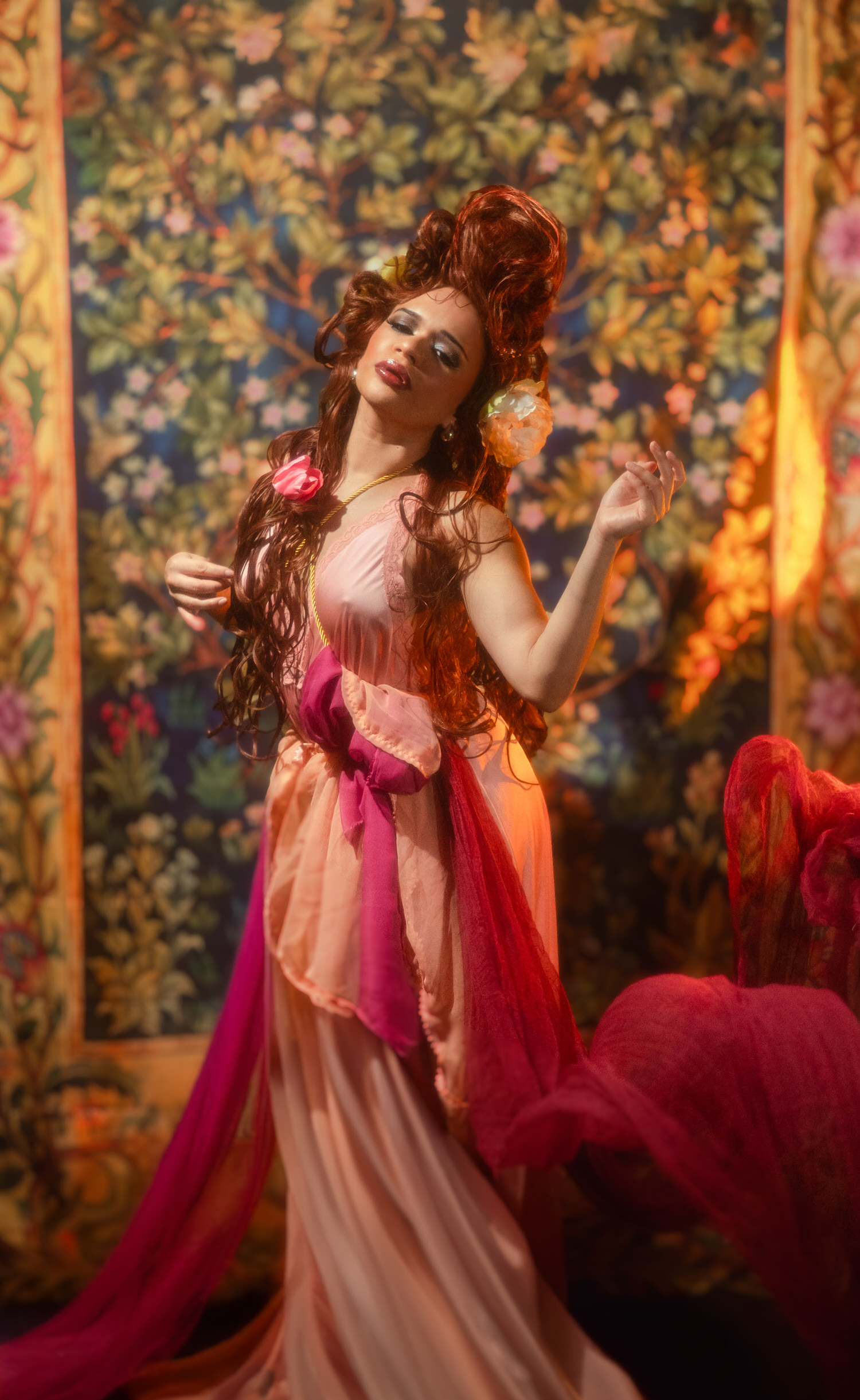 Full length portrait of a woman in a flowing pink and red gown, captured by a Dallas Fort Worth fine art photographer in front of a botanical tapestry, Royal Lune Photo.
