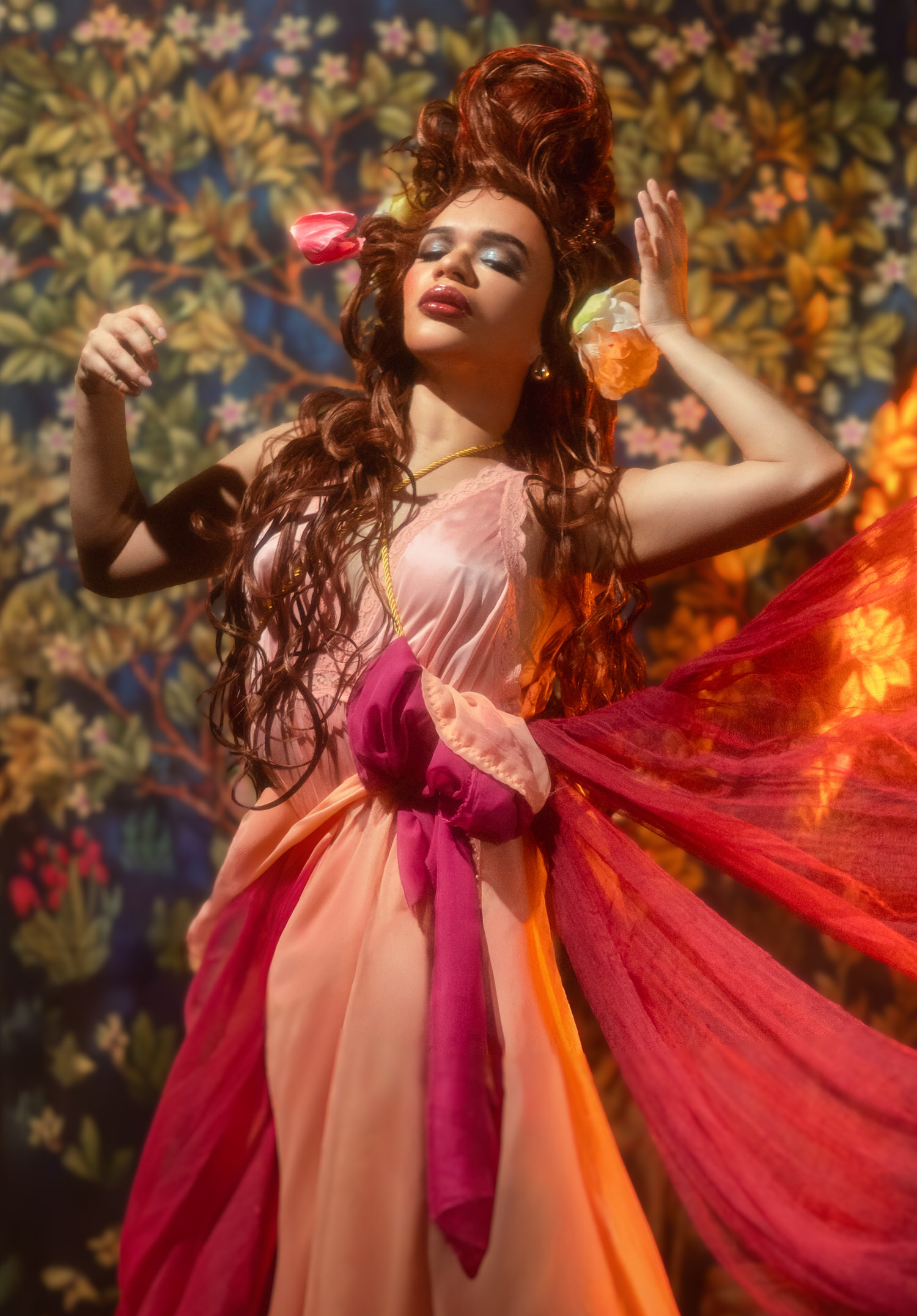 Woman with both arms raised in a dancing pose as sheer red fabric flows beside her during this mucha inspired photoshoot, Royal Lune Photo.