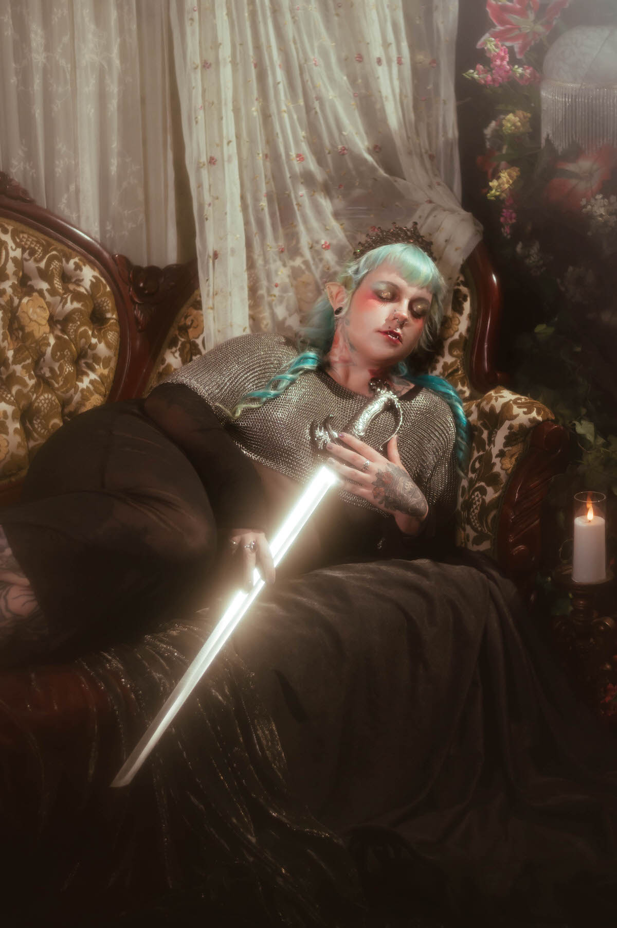 A personal branding photos for artists image of a woman seated on a tufted sofa in twin braids, holding an upright sword with a crystal star ornament resting on the floor beside her, Royal Lune Photo.